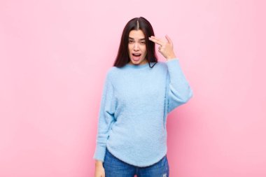 Genç ve güzel bir kadın mutsuz ve stresli görünüyor. İntihar jesti. Elleriyle silah işareti yapıyor.