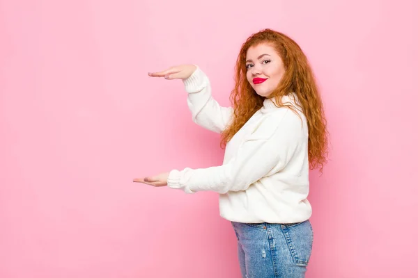 Joven Mujer Cabeza Roja Sosteniendo Objeto Con Ambas Manos Espacio —  Fotos de Stock