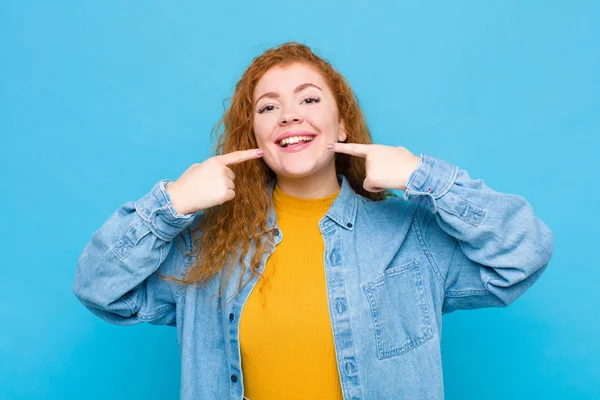 Junge Rote Kopffrau Lächelt Selbstbewusst Und Zeigt Auf Ihr Eigenes — Stockfoto