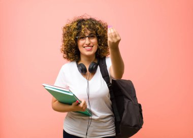 Genç ve güzel bir bayan kapiş ya da para hareketi yapıyor, sana borçlarını ödemeni söylüyor! Pembe duvara yaslan