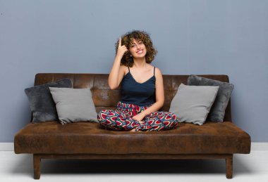 Genç ve güzel bir kadın, harika bir fikri fark ettikten sonra parmağını kaldırıp koltukta oturup 