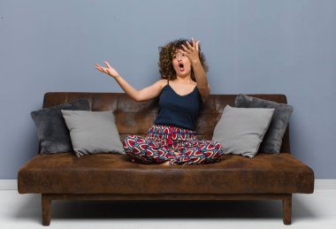 Genç, güzel bir kadın opera yapıyor ya da konserde şarkı söylüyor. Romantik, sanatsal ve tutkulu bir şekilde kanepede oturuyor..