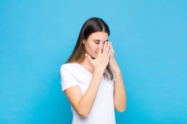 Genç, güzel bir kadın, üzgün, hayal kırıklığına uğramış bir bakışla gözlerini kapatıyor. Ağlıyor, mavi duvara bakıyor.