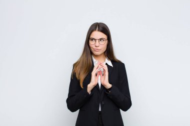 Genç iş kadını kötü bir plan yaparken ya da beyaz duvara karşı bir numara düşünürken gururlu, yaramaz ve kibirli hissediyor.