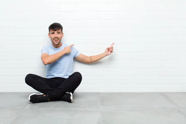 Jovem Homem Bonito Sentindo Chocado Surpreso Apontando Para Copiar Espaço — Fotografia de Stock