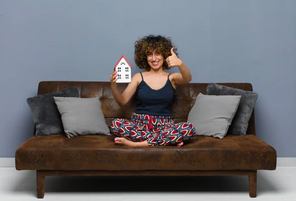 若い可愛い女が家に座ってソファに座ってた家のコンセプト — ストック写真