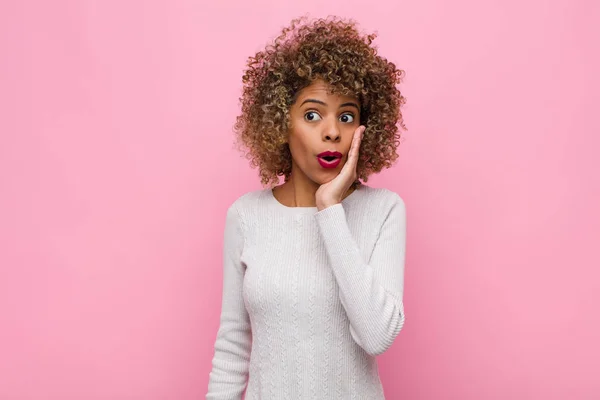 若いアフリカ系アメリカ人の女性はショックを受けピンクの壁に口を開けて不信に手を差し伸べ — ストック写真