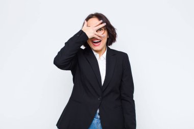 Genç iş kadını şok olmuş, korkmuş ya da korkmuş görünüyordu. Yüzü elle kaplıydı ve parmaklarının arasından beyaz duvara bakıyordu.