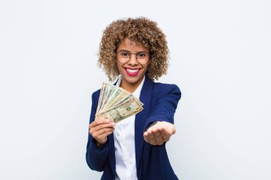 Genç Afrikalı Amerikalı kadın mutlu bir şekilde gülümsüyor, güler yüzle, pozitif bakışla, avro banknotlarıyla bir nesne ya da konsept sunuyor ve gösteriyor