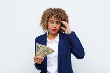 Genç Afrikalı Amerikalı kadın kafası karışık ve şaşkın hissediyor. Deli, deli ya da Euro banknotlarıyla aklını kaçırmış olduğunu gösteriyor.