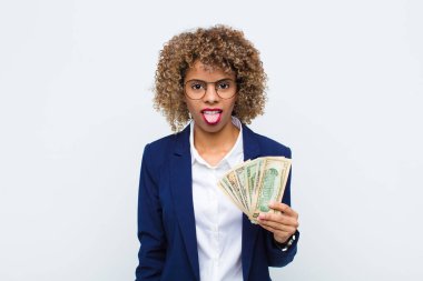 Genç Afrikalı Amerikalı kadın iğrenmiş ve rahatsız olmuş hissediyor. Dilini dışarı çıkarıyor. Avro banknotlarıyla iğrenç ve tiksindirici bir şeyden hoşlanmıyor.