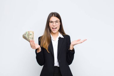 Genç, güzel bir kadın mutlu, heyecanlı, şaşırmış ya da şaşırmış, gülümseyen ve hayrete düşmüş.