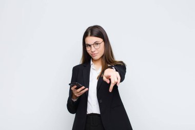 Genç, güzel bir kadın kameraya tatmin olmuş, kendinden emin, arkadaş canlısı bir gülümsemeyle bakıyor ve seni cep telefonuyla seçiyor.