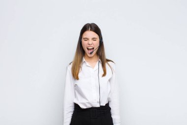 Genç ve güzel bir kadın agresif bir şekilde bağırıyor, sinirli, sinirli, öfkeli ya da sinirli görünüyor, kulaklık ve mikrofonla hayır diye bağırıyor.