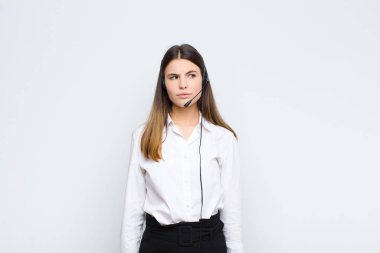 Genç, güzel bir kadın üzgün, üzgün ya da kızgın ve olumsuz bir tavır takınıyor. Kulaklık ve mikrofonla anlaşmazlık içinde.