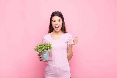 Genç, güzel bir kadın şok olmuş, heyecanlı ve mutlu, gülüyor ve başarıyı kutluyor, vay canına! Bir bitkiyle