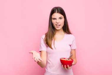 Genç, güzel bir kadın sinirli, sinirli ve sinirli görünüyor. Çığlık atıyor. Ya da kahvaltı kâsesinde ne sorun var?