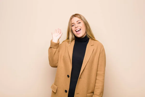 Young Blonde Woman Smiling Happily Cheerfully Waving Hand Welcoming Greeting — 스톡 사진