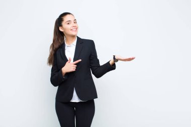 Genç, güzel bir kadın gülümsüyor, mutlu, kaygısız ve tatmin olmuş hissediyor, fotokopi alanındaki konsepte ya da fikre işaret ediyor.