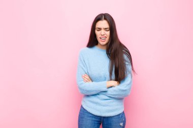 Genç, güzel bir kadın endişeli, hasta, hasta ve mutsuz hissediyor. Ağrılı bir mide ağrısı ya da pembe duvarda grip geçiriyor.