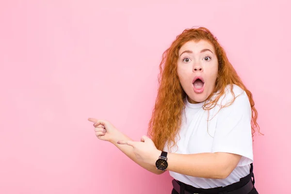 Joven Mujer Pelirroja Que Siente Sorprendida Sorprendida Apuntando Copiar Espacio — Foto de Stock