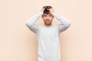 Genç yakışıklı adam hayal kırıklığına uğramış ve sıkılmış hissediyor, başarısızlıktan bıkmış ve bıkmış, sıcak duvara karşı sıkıcı, sıkıcı görevlerden bıkmış