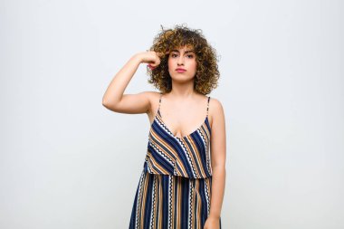 Genç, güzel bir kadın kafası karışık ve şaşkın hissediyor. Deli, deli ya da beyaz duvara karşı aklını kaçırmış olduğunu gösteriyor.