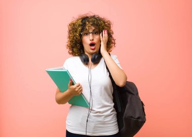 Pembe duvara karşı inanılmaz bir şey fark ettiğinizde genç ve güzel bayan şok olmuş ve şaşırmış görünüyor.