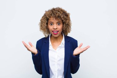 Afro-Amerikan görünümlü genç bir kadın şok ve şaşkınlık içinde, karşısında inanılmaz bir şey fark zaman çene şaşkın düz duvara karşı