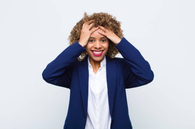 Genç Afro-Amerikan kadını mutlu, kaygısız, arkadaş canlısı ve rahat görünüyor hayattan ve başarıdan keyif alıyor ve yassı duvara karşı pozitif bir tutum sergiliyor. 