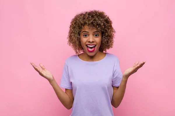 若いアフリカ系アメリカ人の女性はピンクの壁に対して信じられないほどの何かに幸せ 驚きや衝撃を感じ — ストック写真
