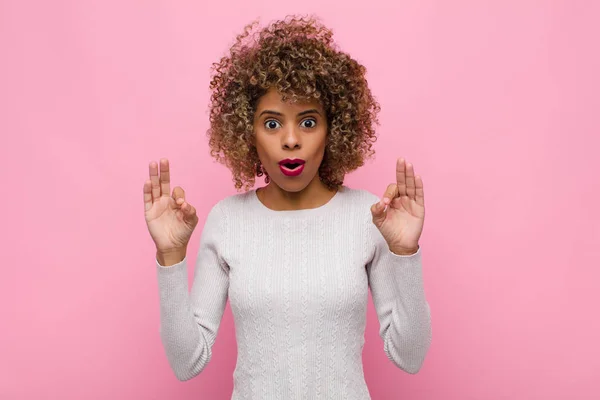 若いアフリカ系アメリカ人女性はショックを受け驚きましたピンクの壁に両手でサインをすることで — ストック写真
