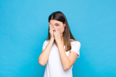 Genç, güzel bir kadın korkmuş ya da utanmış hissediyor. Gözleri yarı kapalı mavi duvara bakıyor ya da dikizliyor.