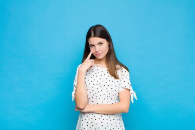 Genç ve güzel bir kadın sana göz kulak oluyor, güvenmiyor, izliyor ve mavi duvara karşı tetikte bekliyor.