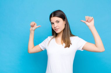 Genç, güzel bir kadın gururlu, kibirli ve kendinden emin görünüyor. Tatmin olmuş ve başarılı görünüyor. Kendini mavi duvara gösteriyor.