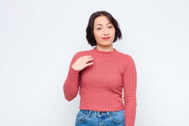 Genç, güzel bir kadın kibirli, başarılı, pozitif ve gururlu görünüyor. Kendini beyaz duvara gösteriyor.