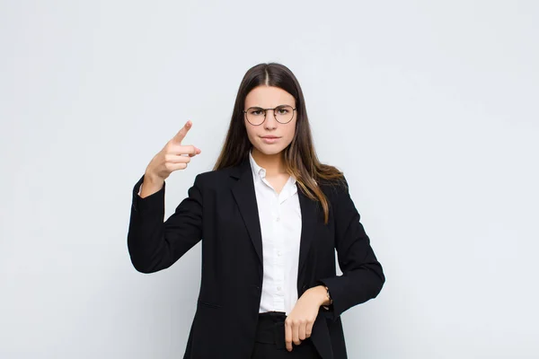 年轻的女商人怒气冲冲地看着相机 一副怒气冲冲的样子 就像一个疯狂的老板靠着白墙 — 图库照片