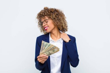 Genç Afrikalı Amerikalı kadın kendini stresli, endişeli, yorgun ve hayal kırıklığına uğramış hissediyor. Gömleğini çekiştiriyor. Avro banknotlarıyla ilgili sorunlardan bıkmış gibi görünüyor.