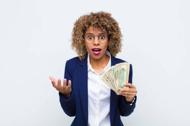Genç Afrikalı Amerikalı kadın ağzı açık ve şaşırmış, şok olmuş ve şaşırmış. Avro banknotları inanılmaz bir sürprizle karşılaşıyor.