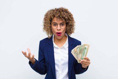 Genç Afro-Amerikan kadını şok olmuş, şaşırmış, endişeli ve paniklemiş hissediyor. Avro banknotlarıyla stresli ve dehşete düşmüş bir bakış atıyor.