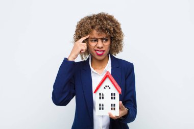 Genç Afrikalı Amerikalı kadın kafası karışık ve şaşkın hissediyor. Bu da deli, deli ya da ev mankeni olduğunu gösteriyor.