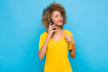 Genç Afrikalı Amerikalı kibirli, başarılı, pozitif ve gururlu görünüyor, cep telefonuyla kendini işaret ediyor.