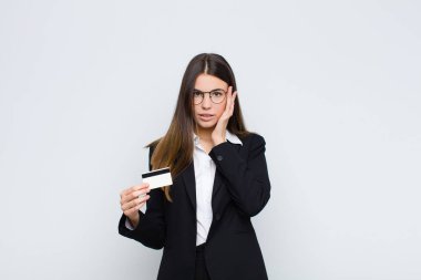 Genç, güzel bir kadın şaşırmış, ağzı açık, şok olmuş, kredi kartıyla yeni bir düşünce, fikir ya da konsept fark ediyor.