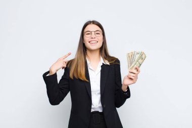 Genç, güzel bir kadın, kendine güvenerek gülümsüyor. Kendi gülüşünü gösteriyor. Olumlu, rahat, banknotlarla tatmin olmuş bir tavır.