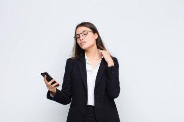 Genç, güzel bir kadın stresli, endişeli, yorgun ve hayal kırıklığına uğramış, yakasını çekiştiren, cep telefonuyla ilgili sorunlardan bıkmış görünüyor.