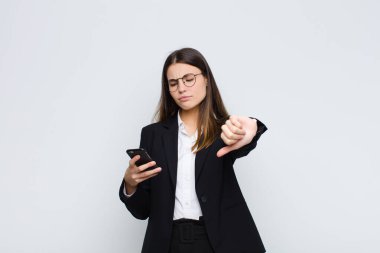 Genç, güzel bir kadın kızgın, sinirli, hayal kırıklığına uğramış ya da hayal kırıklığına uğramış hissediyor. Cep telefonuyla ciddi bir bakış atıyor.