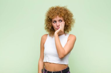 Genç afro kadın yorgun, sıkıcı ve sıkıcı bir görevden sonra sıkılmış, hayal kırıklığına uğramış ve uykulu hissediyor.