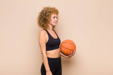 Profil görünümlü genç afro kadın ileriyi kopyalamak istiyor, düşünüyor, hayal ediyor ya da hayal kuruyor spor konseptini hayal ediyor.