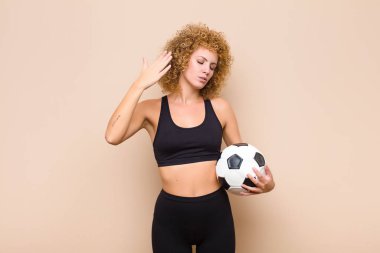 Genç afro kadın stresli, endişeli, yorgun ve hayal kırıklığına uğramış, gömleğini çekmiş, spor konseptinden sıkılmış görünüyor.
