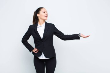 Genç, güzel bir kadın kendini mutlu ve neşeli hissediyor, gülümsüyor ve seni hoş karşılıyor, seni dostça bir jest iş konseptiyle içeri davet ediyor.